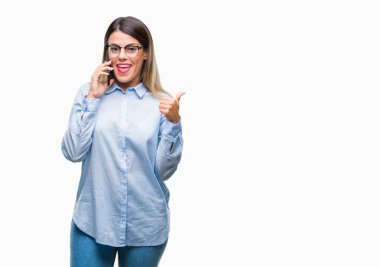 Genç güzel iş kadın konuşma arama Smartphone işaret ve başparmak kadar mutlu yüz gülümseyen tarafı ile gösteren izole arka plan üzerinde kullanma