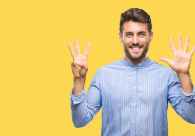 Yakışıklı delikanlı gösterilen ve parmakları ile işaret izole arka plan üzerinde kendinden emin ve mutlu gülümseyerek süre sekiz numara.