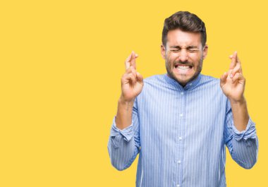 Yakışıklı delikanlı geçiş parmakları umut ve gözleri kapalı ile gülümseyen izole arka plan üzerinde. Şans ve batıl kavramı.