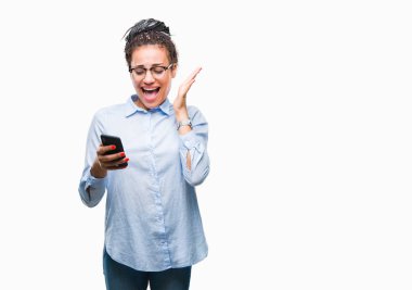 Genç izole arka plan üzerinde çok mutlu ve heyecanlı, kocaman bir gülümseme ile çığlık ve ellerini kaldırdı kazanan ifade kutluyor zafer smartphone kullanan saç Afro-Amerikan iş kız örgülü