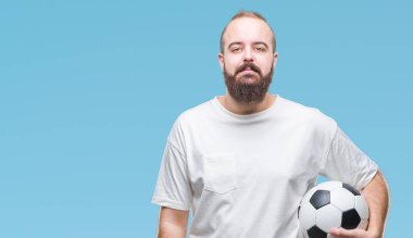 Acımak yüz ciddi düşünüyorum üstünde kendine güvenen bir ifade ile izole arka plan üzerinde futbol futbol topu tutan genç beyaz hipster adam