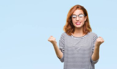 Genç güzel kadın kutluyor gözlük takan izole arka plan yüzünden şaşırttı ve silah ile başarı için yükseltilmiş ve açık gözler hayrete düşürdü. Kazanan kavramı.