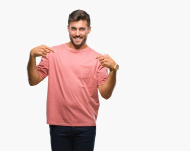 Yüzünde gülümseme ile kendinden emin görünüyorsun, kendini gururlu ve mutlu parmakları ile işaret izole arka plan üzerinde genç yakışıklı adam.