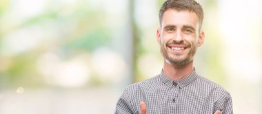 Genç hipster adam kameraya mutlu ve komik suratla parmakları işaret. İyi enerji ve vibes.