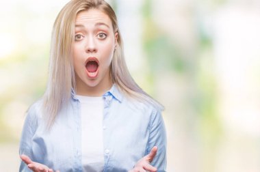 Genç Sarışın kadın izole arka plan korkuyor ve sürpriz ifade ile şok yüzünden korku ve yüz heyecanlı.