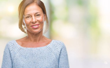 Orta yaş İspanyol kadın kıdemli giyen kış kazak izole arka plan ile bir mutlu ve serin üzerinden yüzündeki gülümseme. Şanslı kişi.