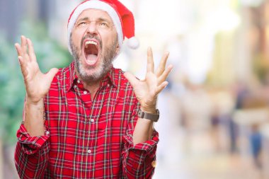 Orta yaş ağarmış komuta sizde Noel şapka üzerinde arka plan deli izole ve deli bağırarak ve agresif ifade ve silah kaldırdı bağırıyor. Hayal kırıklığı kavramı.