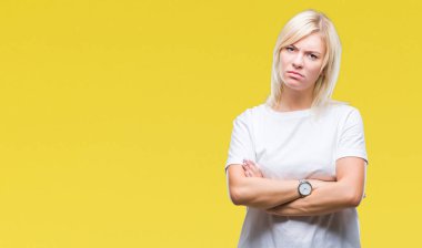İzole arka plan şüpheci ve sinir, onaylamayan ifade yüz çapraz kolları üzerinde beyaz t-shirt giyen genç güzel sarışın kadın. Negatif kişi.