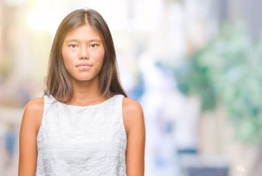 Genç Asyalı kadın yüzünde ciddi bir ifade ile izole arka plan üzerinde. Basit ve doğal kameraya bakıyor.