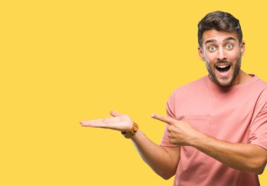 Yakışıklı delikanlı üzerinden hayran ve el ile sunulması ve parmak ile işaret ederken kameraya gülümseyen izole arka plan.