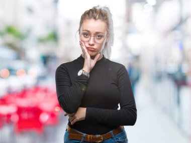 Seyir yorgun ve bıkkın ile depresyon sorun Çapraz kollar ile izole arka plan düşünme üzerinde gözlüklü sarışın genç kadın.