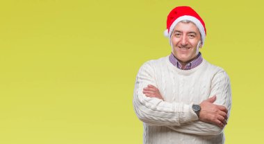 Üst düzey yakışıklı Noel şapka üzerinde mutlu yüz ile gülümseyerek kameraya seyir silah geçti arka plan izole. Olumlu bir kişi.