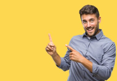 Yakışıklı delikanlı gülümseyen ve iki elleri ve parmakları ile tarafına işaret kamera bakarak izole arka plan üzerinde.