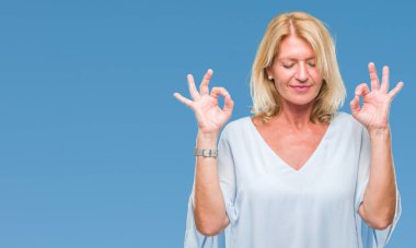 Orta yaş sarışın iş kadını izole arka plan üzerinde dinlenmek ve gülümseyen gözlerle parmak ile meditasyon jest yapıyor kapalı. Yoga kavramı.
