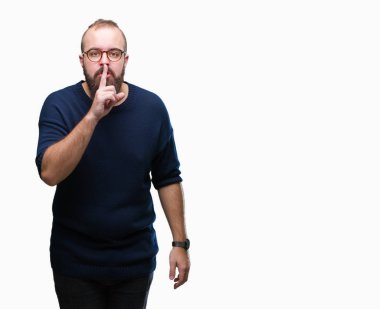 Genç beyaz hipster adam dudaklarında parmak ile sessiz olmanı izole arka plan üzerinde güneş gözlüğü takıyor. Sessizlik ve gizli kavramı.