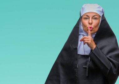 Orta yaş üst düzey Hıristiyan Katolik Rahibe kadın dudaklarında parmak ile sessiz olmanı izole arka plan yüzünden. Sessizlik ve gizli kavramı.