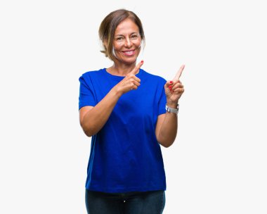 Orta yaş üst düzey İspanyol kadın gülümseyerek ve iki elleri ve parmakları ile tarafına işaret kamera bakarak izole arka plan.