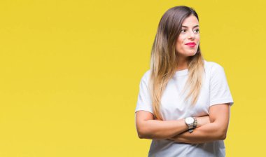 Genç güzel kadın rahat görünümlü yan ve dik dik bakma uzağa düşünce gülümseyen izole arka plan üzerinde beyaz t-shirt.