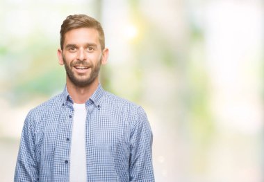 Yüzünde mutlu ve güzel bir gülümseme ile izole arka plan üzerinde beyaz t-shirt giyen genç yakışıklı adam. Şanslı kişi.