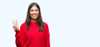 Kadar kırmızı kazaklı gösterme ve işaret parmakları ile giyen genç güzel İspanyol üçüncü ise kendinden emin ve mutlu gülümseyerek.