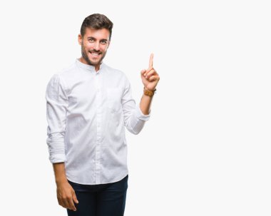 Kameraya bakarak yan el ve parmak ile işaret eden genç yakışıklı adam yüzünde kocaman bir gülümseme ile izole arka plan üzerinde.