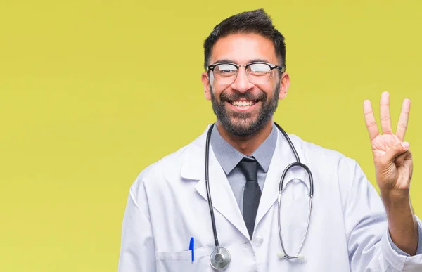 成人拉美裔医生男子在孤立的背景显示和指向与手指数字三同时微笑自信和快乐 — 图库照片