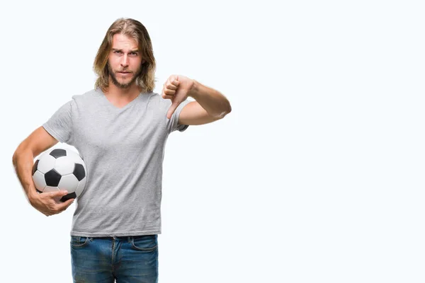 サッカー ボールの怒った顔 ダウン親指で嫌悪感を示すマイナス記号 拒絶反応の概念を保持している分離の背景の上の長い髪の若いハンサムな男 — ストック写真