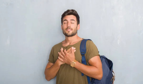 Guapo Turista Joven Sobre Gris Pared Grunge Con Mochila Sonriendo —  Fotos de Stock