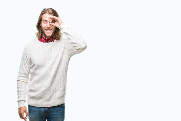 幸せそうな顔で指を通して見る目の手で のジェスチャーを行う分離の背景に冬のセーターを着ている髪の長い若いハンサムな男 — ストック写真