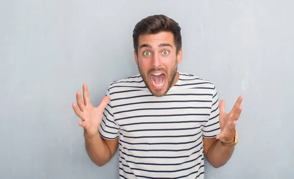 Hombre Joven Guapo Sobre Pared Gris Grunge Usando Camiseta Azul — Foto de Stock