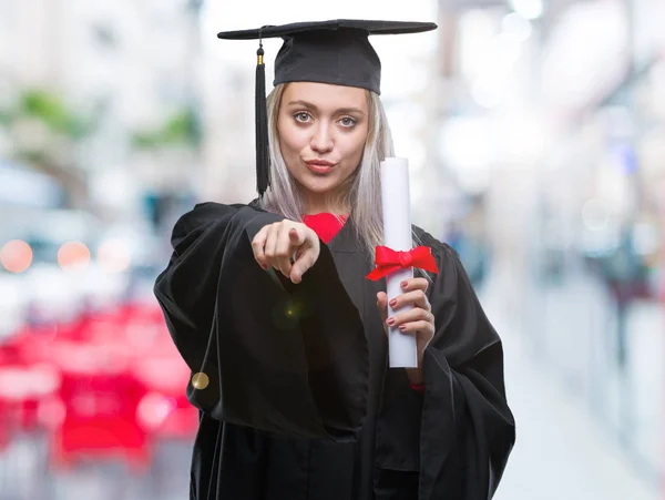 若いブロンドの女性カメラと指で指している孤立の背景の上の身に着けている大学院の均一保持度 手に署名 正面からポジティブで自信のジェスチャー — ストック写真