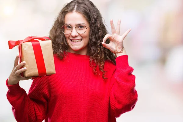 Young Brunette Girl Holding Gift Isolated Background Doing Sign Fingers — Stock Photo, Image