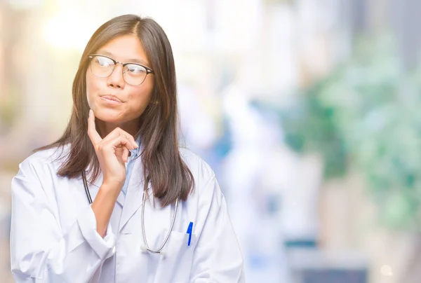 若いアジア医師女性あごを考えて質問 物思いにふける式の手で隔離された背景の上 思いやりのある顔をして笑っています 疑いのコンセプト — ストック写真