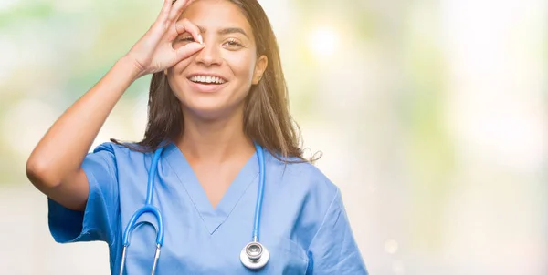 幸せそうな顔で指を通して見る目の手で のジェスチャーを行う分離の背景の上の若いアラブ医師外科医女 — ストック写真