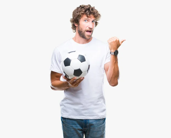 ハンサムなヒスパニック系男性モデルを指していると幸せそうな顔を笑顔で側まで親指で示す分離の背景にサッカー サッカー ボールを保持 — ストック写真