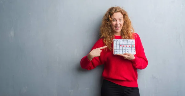 Joven Pelirroja Mujer Sobre Gris Grunge Pared Celebración Período Calendario — Foto de Stock