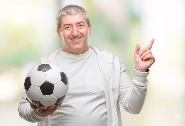 ハンサムな年配の男性側の手と指で指す非常に幸せの孤立した背景にサッカー サッカー ボールを保持しています — ストック写真