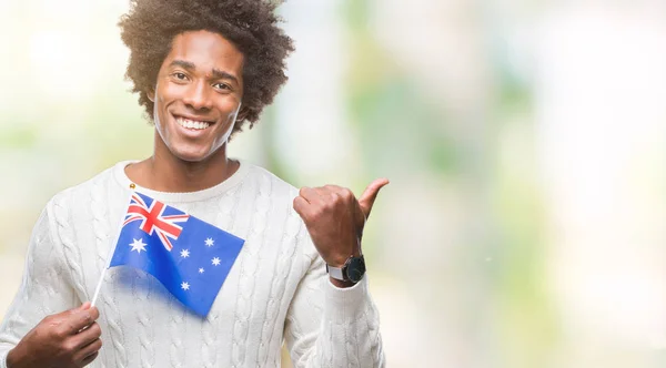 指していると幸せそうな顔を笑顔で側まで親指で示す分離の背景にオーストラリアのアフロ アメリカ人フラグ — ストック写真