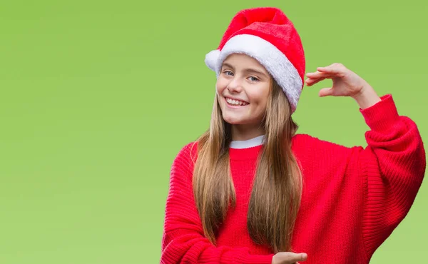 上クリスマス帽子身に着けている美しい少女は 背景がメジャー シンボル兆し大きな 大きなサイズの手でジェスチャーを分離しました カメラを見て笑っています 測定概念 — ストック写真