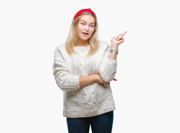 カメラを見ている側の手と指で指すの顔に大きな笑みを浮かべて隔離された背景に冬のセーターを着ている若い白人女性 — ストック写真