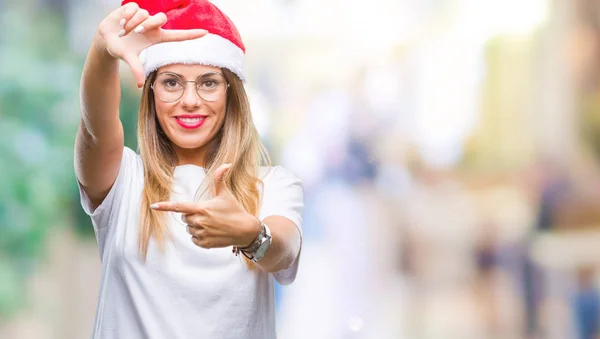 年轻美丽的妇女戴着圣诞节帽子在孤立的背景微笑制作框架用手和手指与快乐的脸 创意与摄影理念 — 图库照片