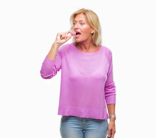 Średnim Wieku Kobieta Blonde Eatin Różowy Macaron Herbatniki Białym Tle — Zdjęcie stockowe