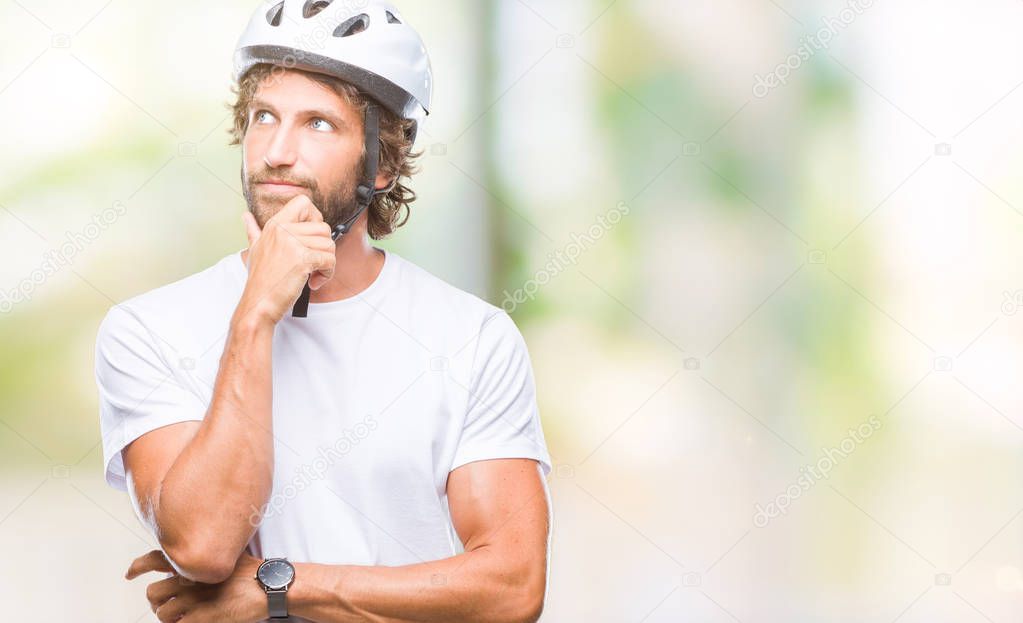 Handsome hispanic cyclist man wearing safety helmet over isolated background with hand on chin thinking about question, pensive expression. Smiling with thoughtful face. Doubt concept.