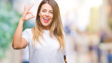 Genç güzel kadın rahat beyaz t-shirt üzerine arka plan el ve parmaklar ok işaretiyle yapıyor olumlu gülümseyen izole. Başarılı ifade.