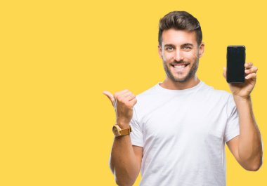 Yakışıklı delikanlı gösteren smartphone ekran işaret ve başparmak kadar mutlu yüz gülümseyen tarafı ile gösteren izole arka plan üzerinde