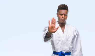 İzole arka stop yapıyor kimono giyen genç Afro-Amerikan adam elin avuç ile şarkı. Negatif ve ciddi bir jest yüz ifadesiyle uyarı.