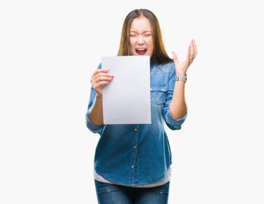 Boş kağıt sayfası tutan genç beyaz kadın büyük gülümseme ile çığlık zaferini kutluyor ve ellerini kaldırdı arka plan çok mutlu ve heyecanlı, kazanan ifade izole