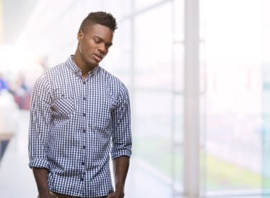 Mavi gömlek seksi bir ifadeyle, neşeli ve mutlu yüzünü kameraya bakarak göz kırpıyor giyen genç Afro-Amerikan adam.