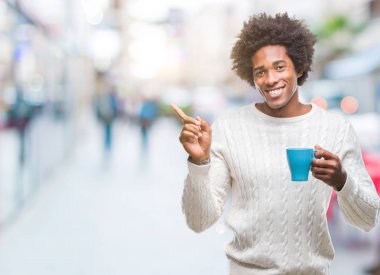 Afro Amerikalı adam izole arka tarafına el ve parmak ile işaret çok mutlu üzerinde kahve içme