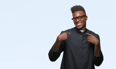 Yüzünde gülümseme ile kendinden emin görünüyorsun, kendini gururlu ve mutlu parmakları ile işaret izole arka plan genç Afro-Amerikan rahip adam.